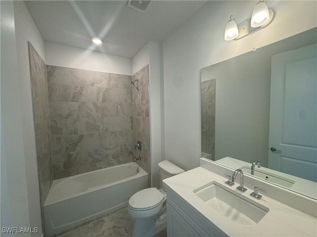 full bathroom featuring tiled shower / bath combo, toilet, and vanity