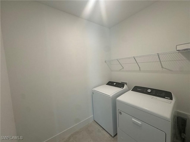 washroom with washing machine and clothes dryer and light tile patterned flooring