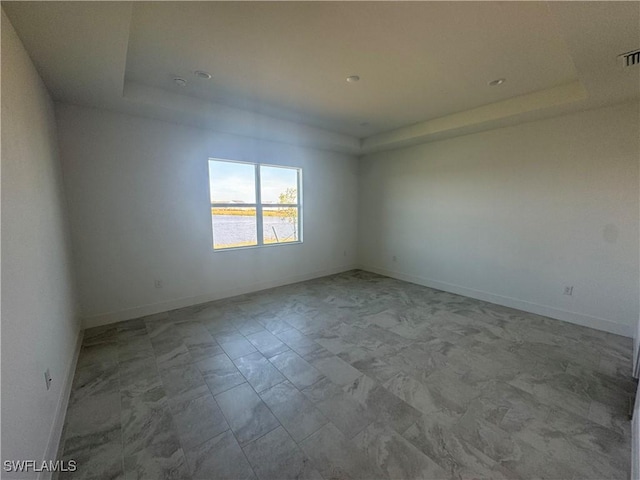 spare room with a raised ceiling