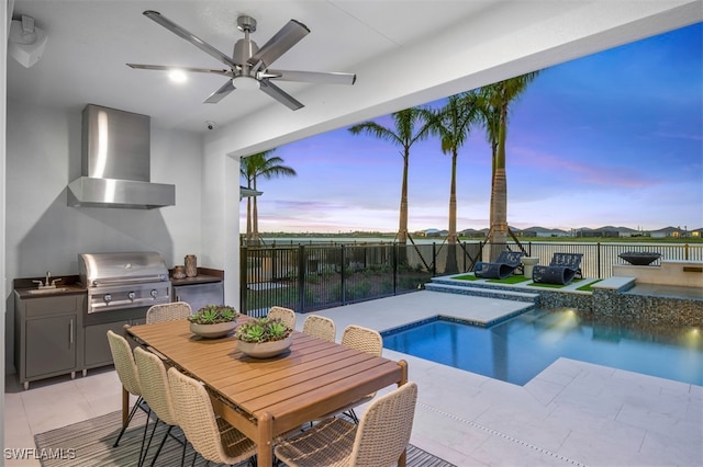 pool at dusk with an outdoor kitchen, area for grilling, sink, a jacuzzi, and a patio area