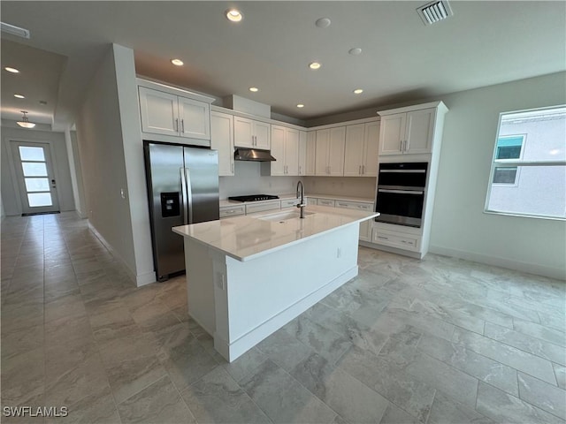 kitchen featuring double oven, under cabinet range hood, a sink, visible vents, and stainless steel refrigerator with ice dispenser