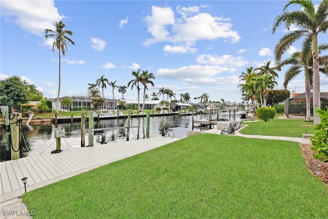 view of dock with a yard and a water view