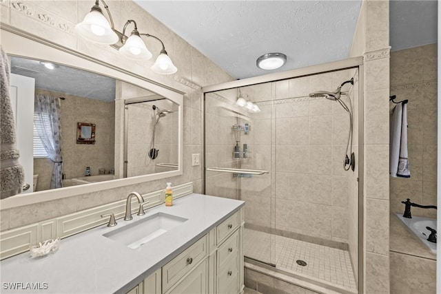 bathroom with vanity, independent shower and bath, and a textured ceiling