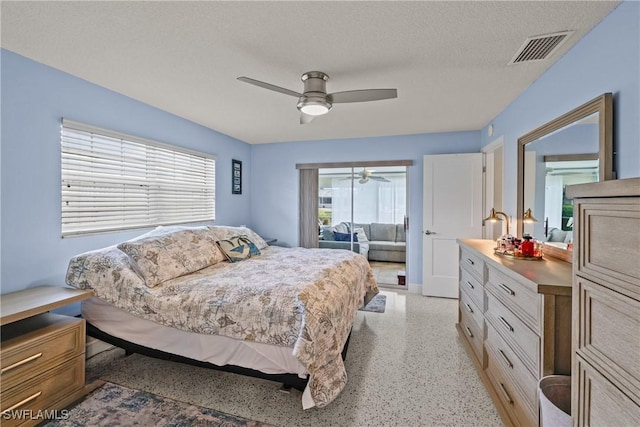 bedroom featuring multiple windows, ceiling fan, and a textured ceiling