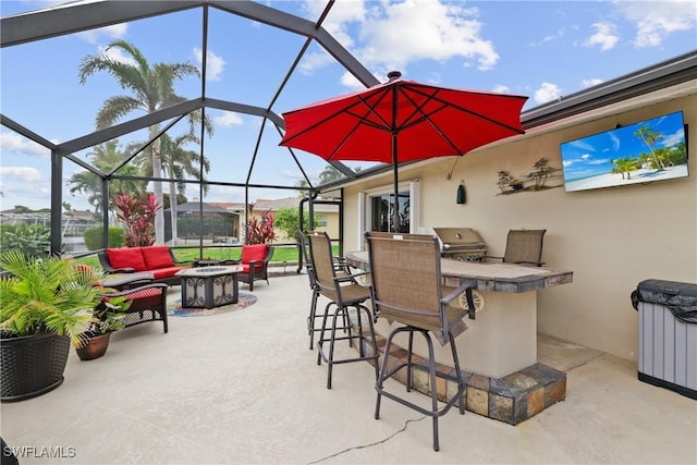 view of patio featuring exterior bar, area for grilling, an outdoor living space with a fire pit, and a lanai