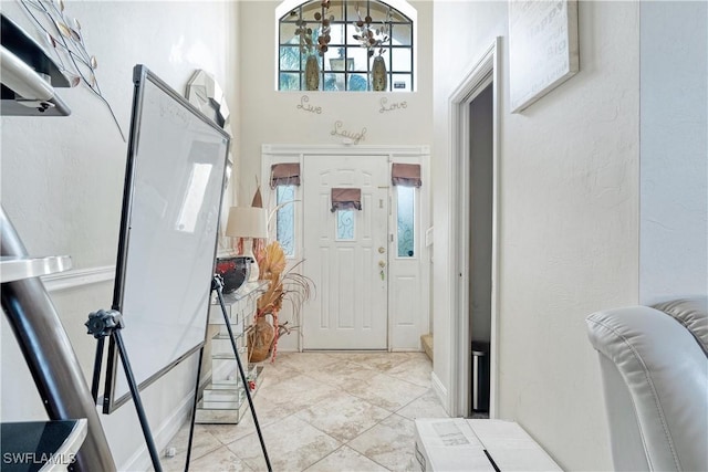 tiled entrance foyer with a notable chandelier