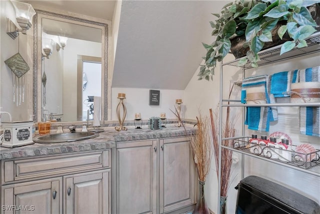 bathroom featuring vanity and lofted ceiling