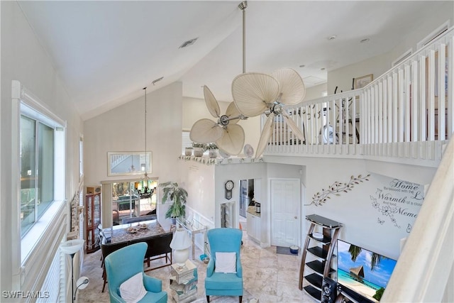 living room featuring ceiling fan with notable chandelier and high vaulted ceiling