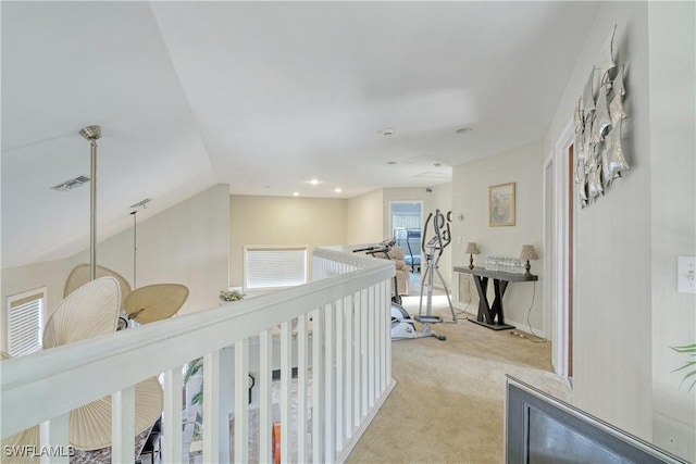 corridor featuring light colored carpet and vaulted ceiling