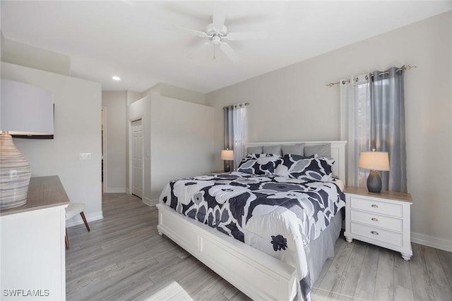 bedroom with a closet, light hardwood / wood-style flooring, and ceiling fan