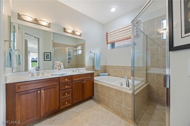 bathroom featuring shower with separate bathtub, vanity, and tile patterned floors