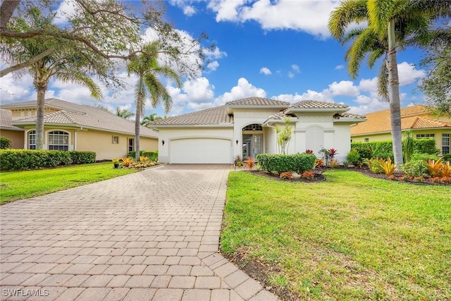 mediterranean / spanish-style home featuring a front yard and a garage