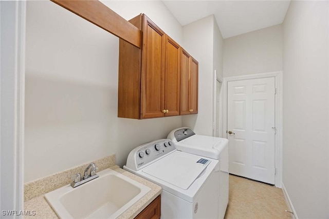 laundry room with cabinets, washing machine and dryer, light tile patterned flooring, and sink