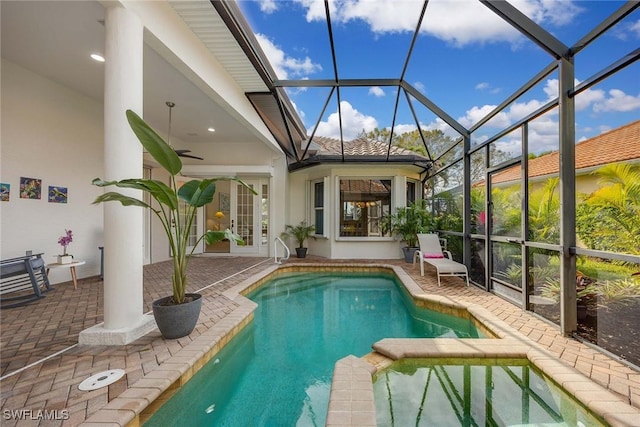 view of swimming pool with a lanai, a patio area, and ceiling fan