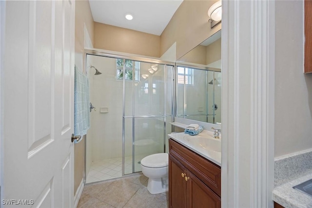 bathroom featuring tile patterned floors, vanity, an enclosed shower, and toilet