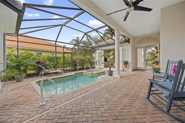 view of swimming pool featuring ceiling fan, a patio area, a lanai, and an in ground hot tub