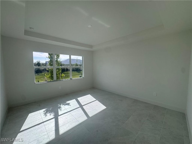 unfurnished room featuring a tray ceiling