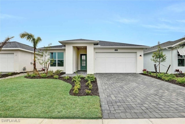 44402 Panther Dr, Punta Gorda, FL 33982 - prairie-style home with decorative driveway, an attached garage, stucco siding, and a front lawn