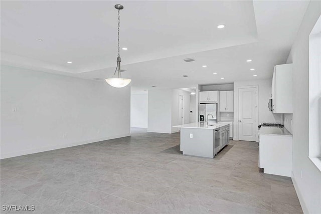 kitchen featuring sink, white cabinetry, decorative light fixtures, an island with sink, and stainless steel appliances