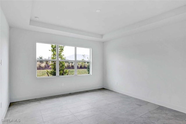 empty room featuring a raised ceiling