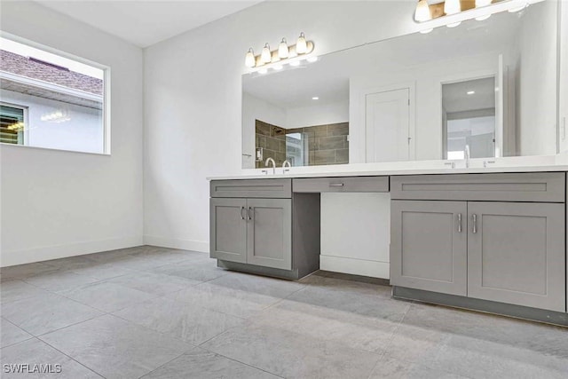 bathroom with vanity and a tile shower