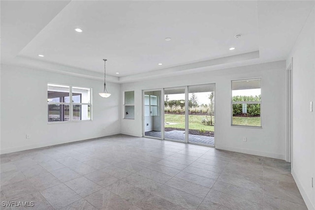 unfurnished room featuring a tray ceiling, baseboards, and recessed lighting