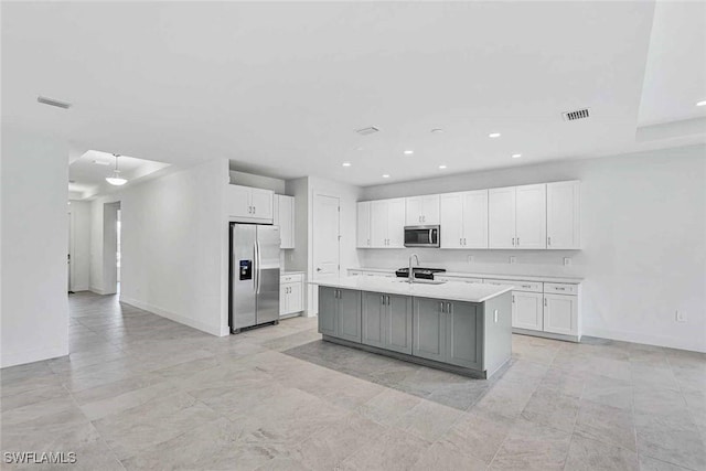 kitchen with sink, gray cabinets, stainless steel appliances, a kitchen island with sink, and white cabinets