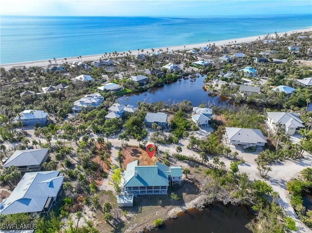 bird's eye view with a water view and a beach view