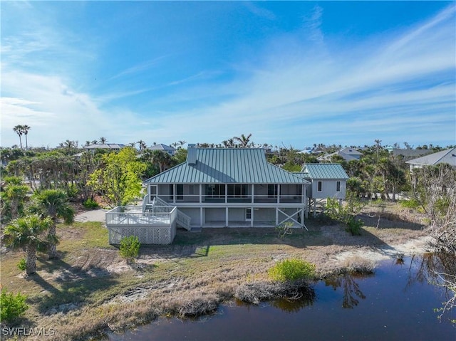 rear view of property with a water view and a lanai