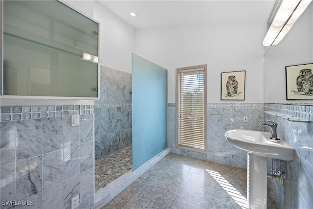 bathroom featuring tile patterned floors, tile walls, and a shower