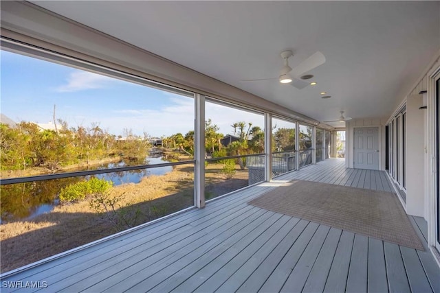 wooden deck with a water view and ceiling fan