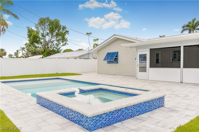 view of swimming pool featuring a sunroom, an in ground hot tub, and a patio