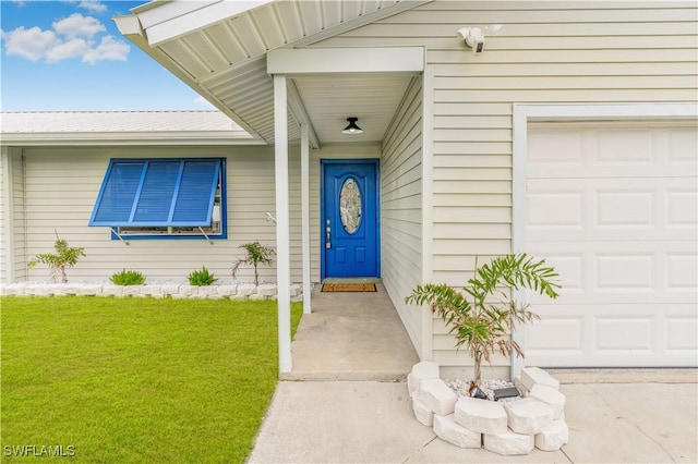 entrance to property with a garage and a yard