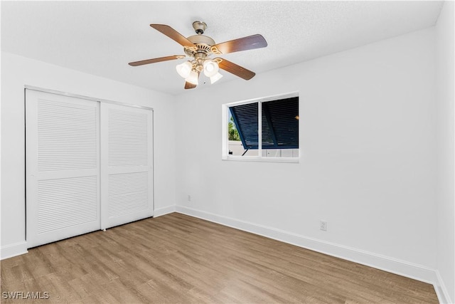 unfurnished bedroom with ceiling fan, light hardwood / wood-style floors, and a closet