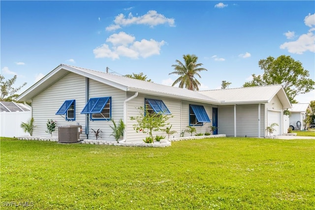 ranch-style house with a front yard, a garage, and central air condition unit