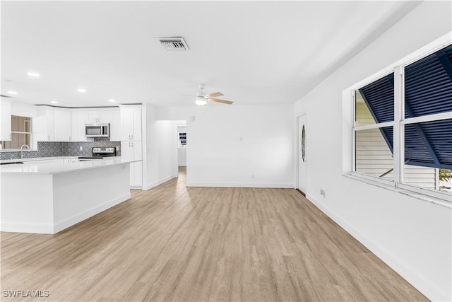 unfurnished living room with light wood-type flooring and ceiling fan