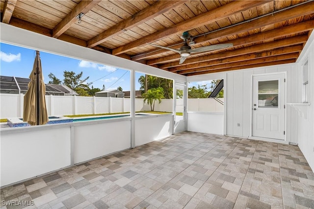 unfurnished sunroom featuring beamed ceiling and wood ceiling