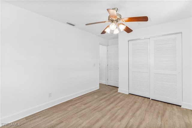 unfurnished bedroom with ceiling fan, light hardwood / wood-style flooring, and a closet