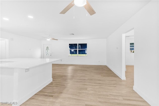 unfurnished living room featuring ceiling fan and light wood-type flooring