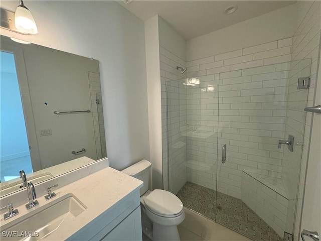 bathroom featuring tile patterned floors, a shower with door, vanity, and toilet