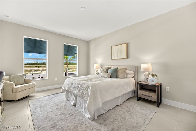 bedroom with light tile patterned flooring and baseboards