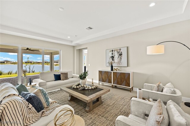 living room featuring recessed lighting, a water view, baseboards, and visible vents