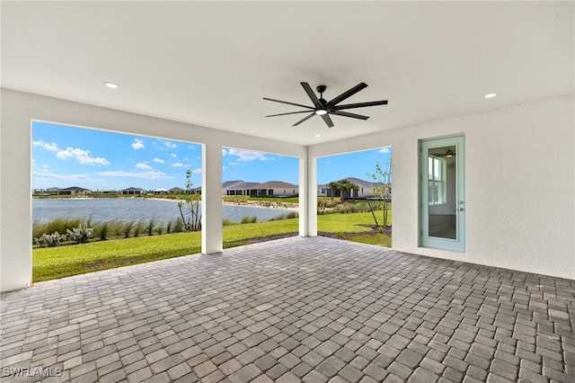 view of patio / terrace featuring a water view and ceiling fan
