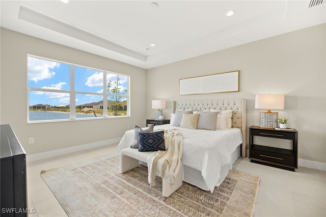 bedroom with a raised ceiling, light tile patterned floors, baseboards, visible vents, and recessed lighting