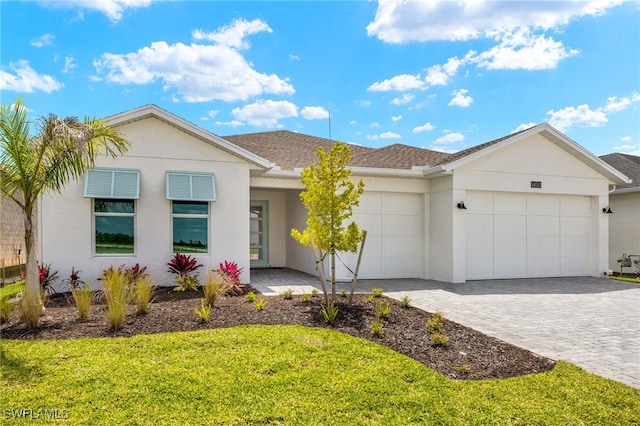 ranch-style home with stucco siding, decorative driveway, a front yard, a garage, and a shingled roof