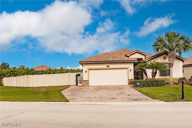 mediterranean / spanish house with a garage and a front lawn