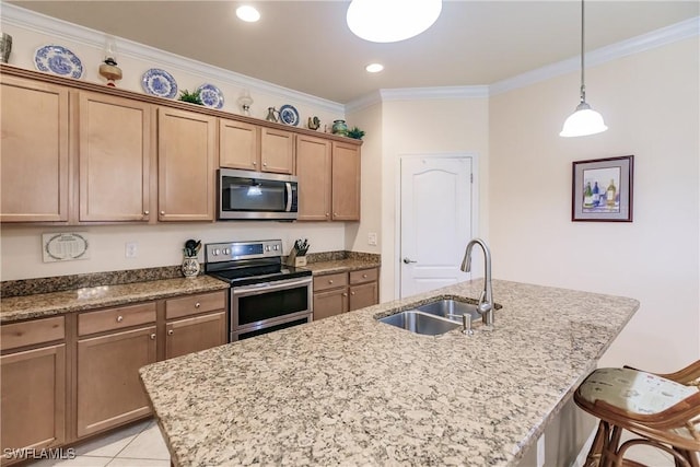 kitchen with a kitchen bar, appliances with stainless steel finishes, a kitchen island with sink, and sink