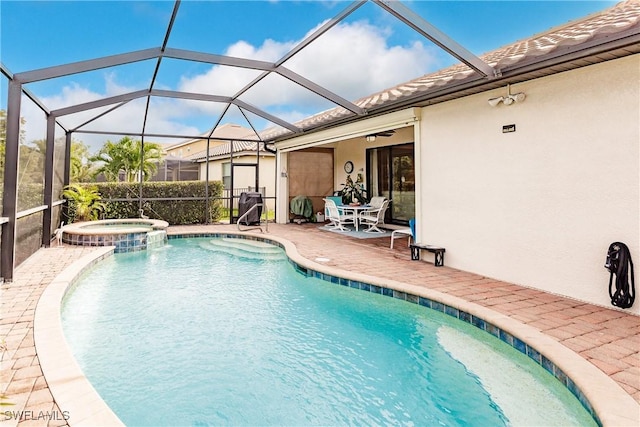 view of pool with an in ground hot tub, a patio, glass enclosure, and ceiling fan