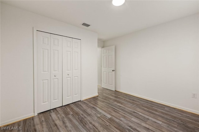 unfurnished bedroom with hardwood / wood-style flooring and a closet