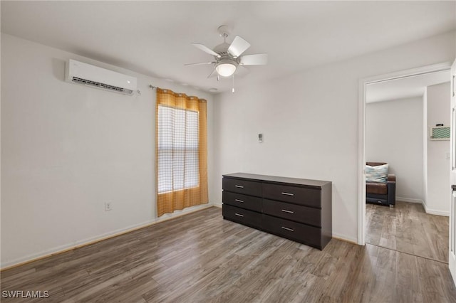 bedroom featuring ceiling fan, light hardwood / wood-style floors, and a wall mounted air conditioner